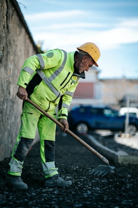 Travailleur du BTP ratissant un chantier à Annecy