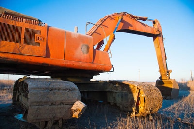 Mini-shovel at rest on an earthwork site