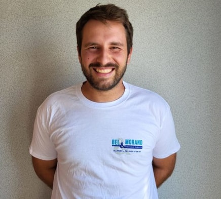 Homme souriant en chemise blanche avec logo BTP